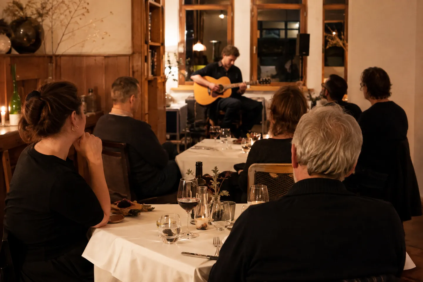 Illustrative Szene: Ein gemütlicher Live-Musik-Abend in einem Restaurant